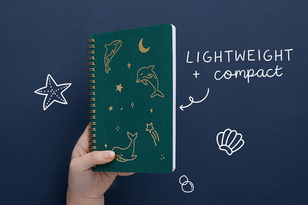 Tsuki Ocean Edition Ring Bound notebook in deep teal with lightweight and compact design held in hand in dark blue background