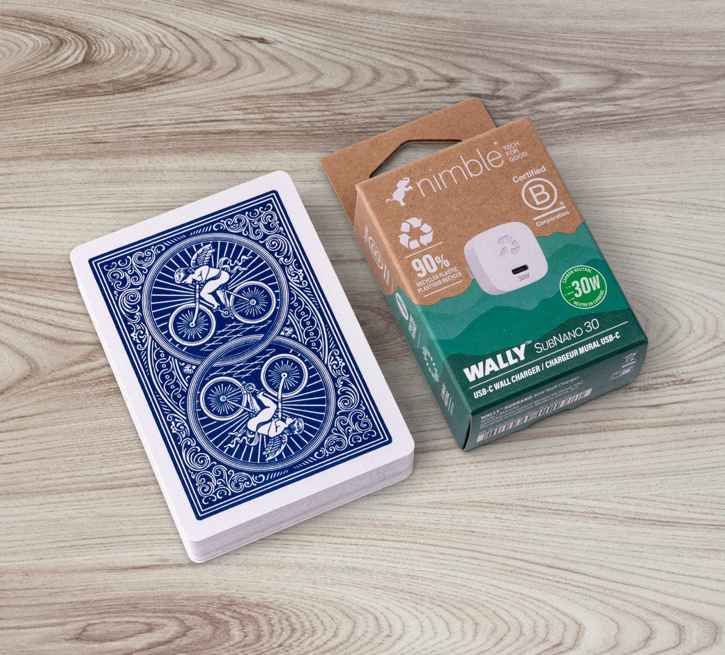 Nimble Wally SubNano 30W USB-C wall charger box next to a deck of playing cards for size comparison.