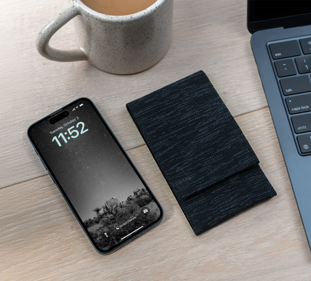 USB-C cable connected to a laptop, secured with a black strap.