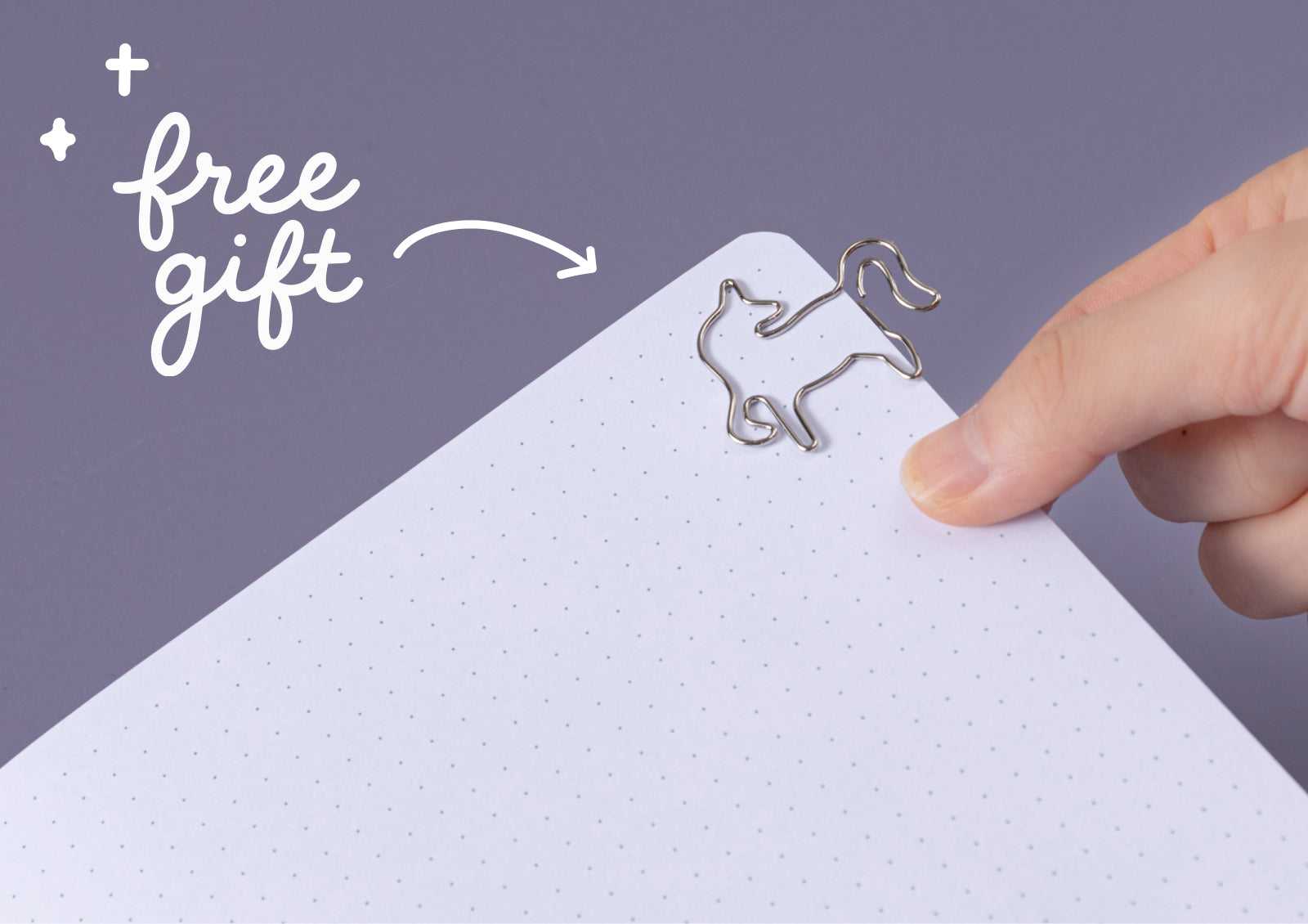 Hand opening Tsuki Moonflower Magic Lunar Unicorn Notebook, displaying dotted pages inside.