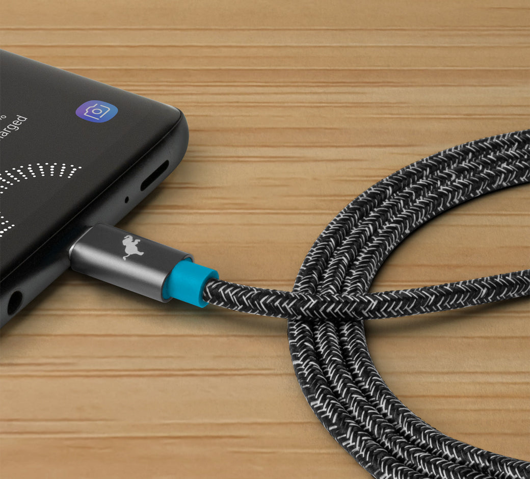 Close-up of a USB-C cable with a woven black and white exterior connected to a smartphone.