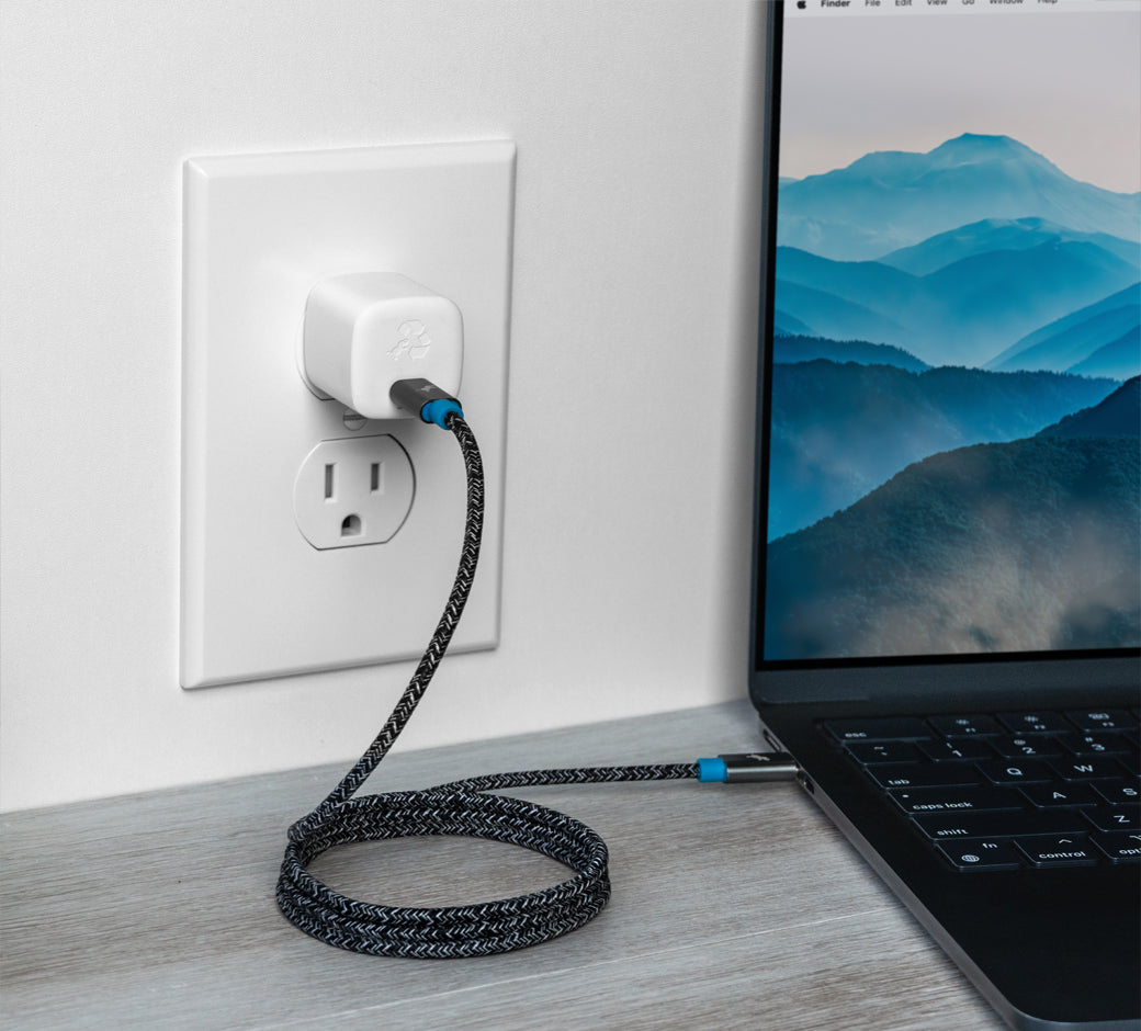 White 30W USB-C charger plugged into a wall outlet with a laptop connected via a braided cable