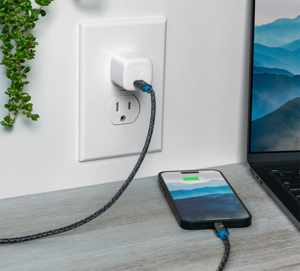 White 30W USB-C charger plugged into a wall outlet with a laptop connected via a braided cable.