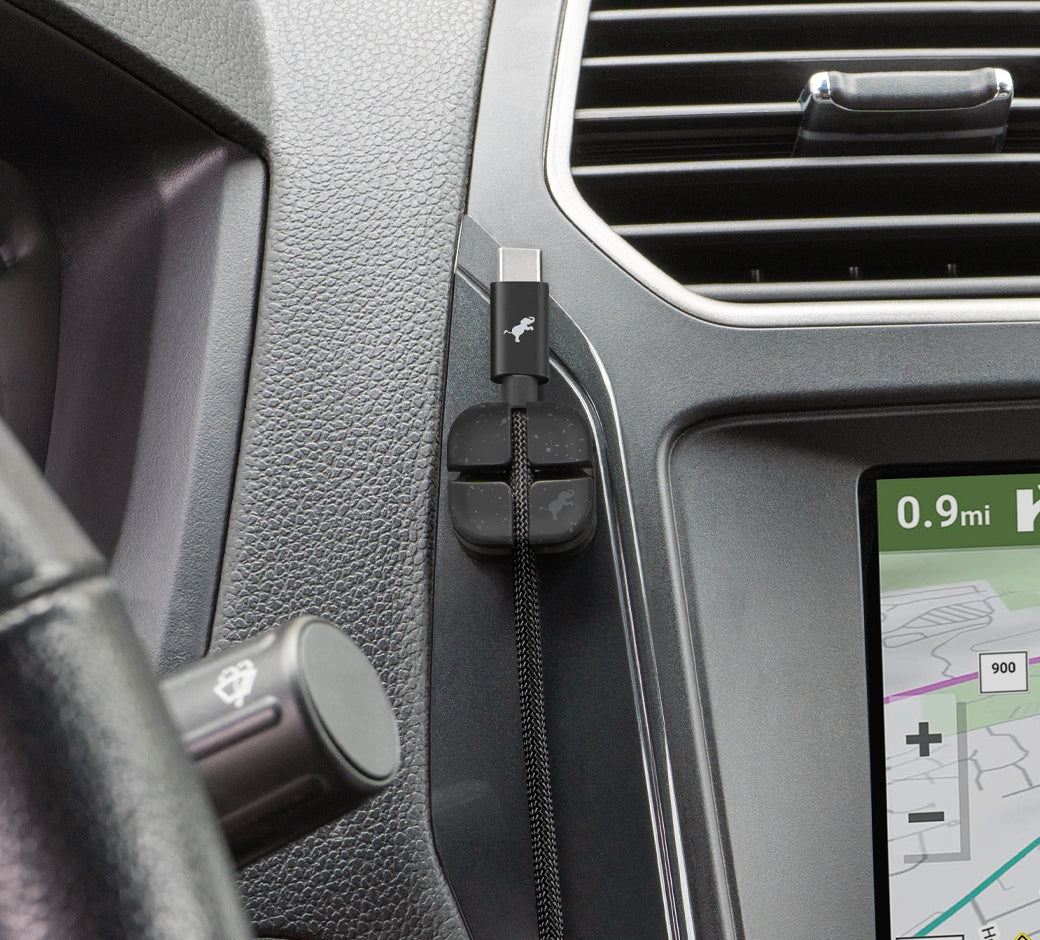 Magnetic cable organizer holding USB-C cable next to car navigation system.