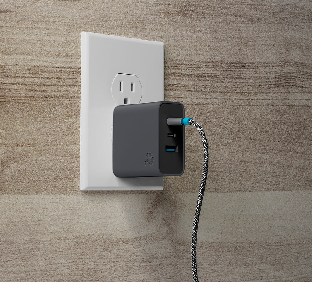 USB-C wall charger plugged into a wall socket, with a braided charging cable connected.