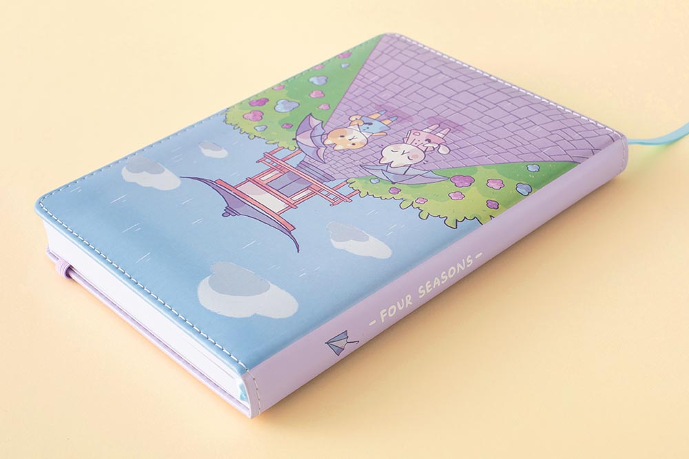 Close up of Tsuki Four Seasons: Summer Edition Bullet Journal designed with @milkkoyo at an angle on honey yellow background