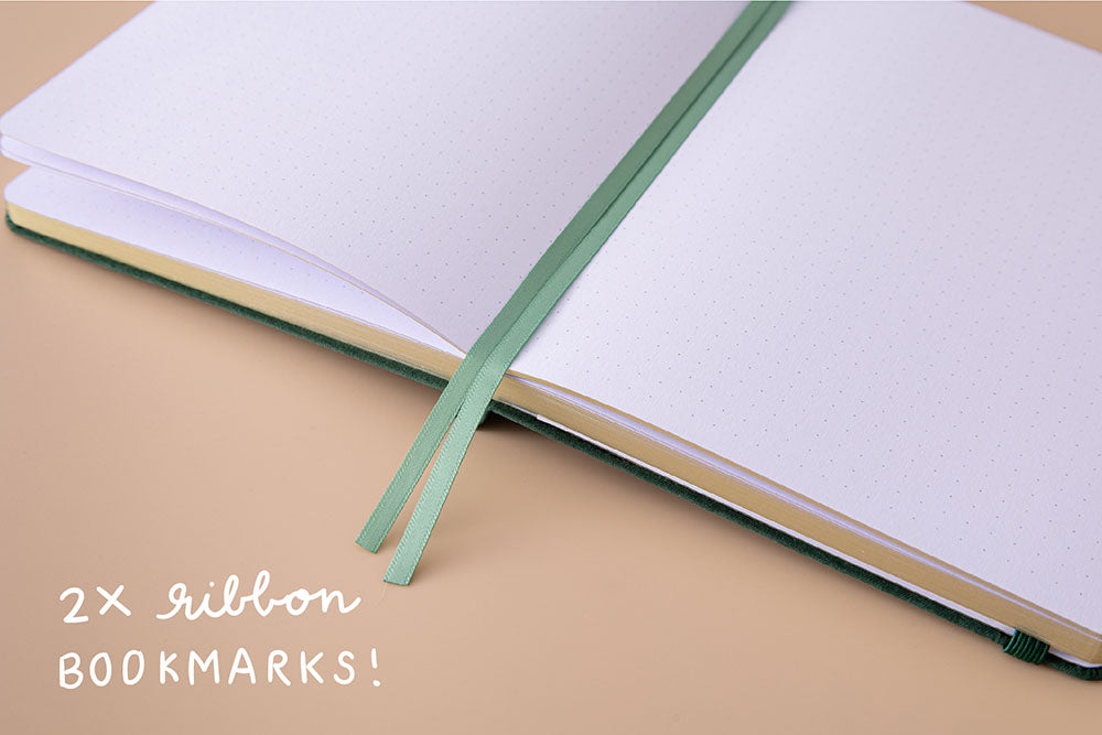 Open page spread of Tsuki ‘Midnight Garden’ Limited Edition Bullet Journal with two bookmark ribbons on beige background