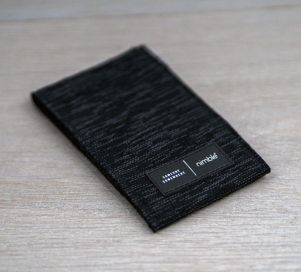 Black Nimble branded pouch on a wooden surface.