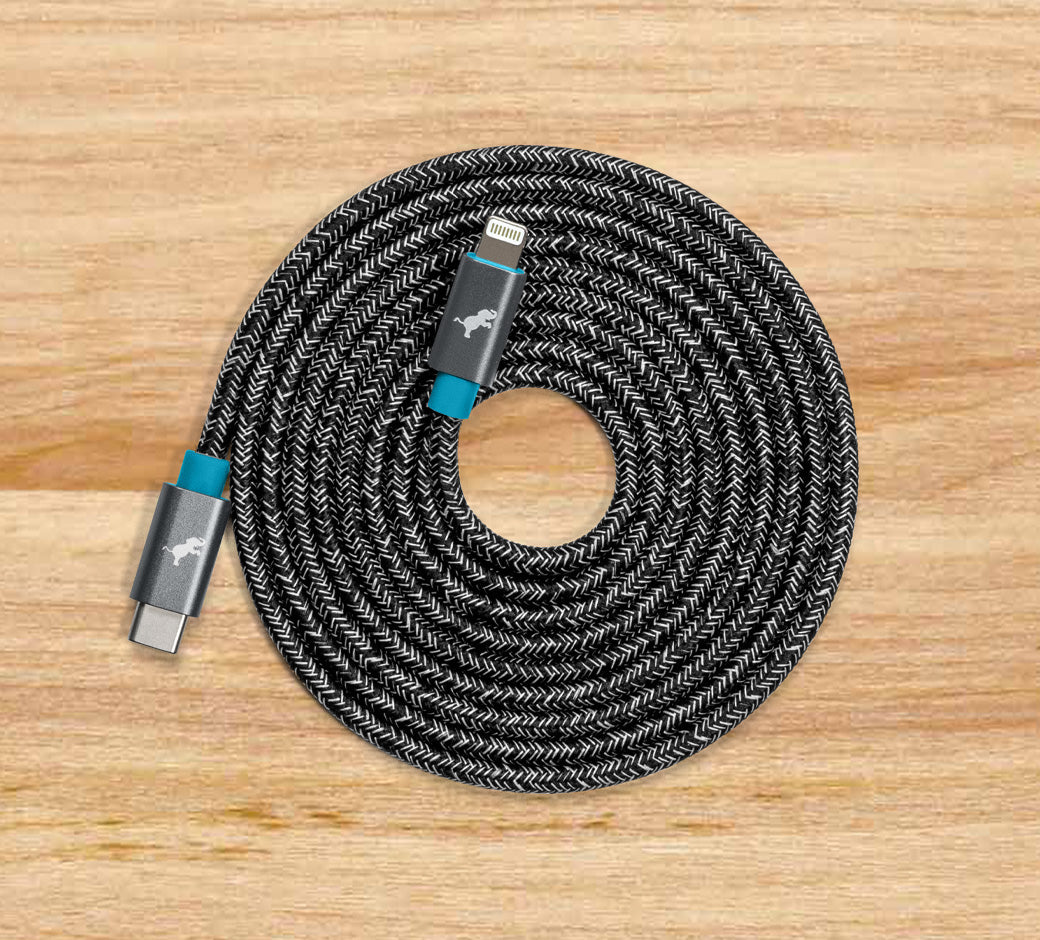 Coiled braided USB-C to Lightning charging cable on a wooden surface.