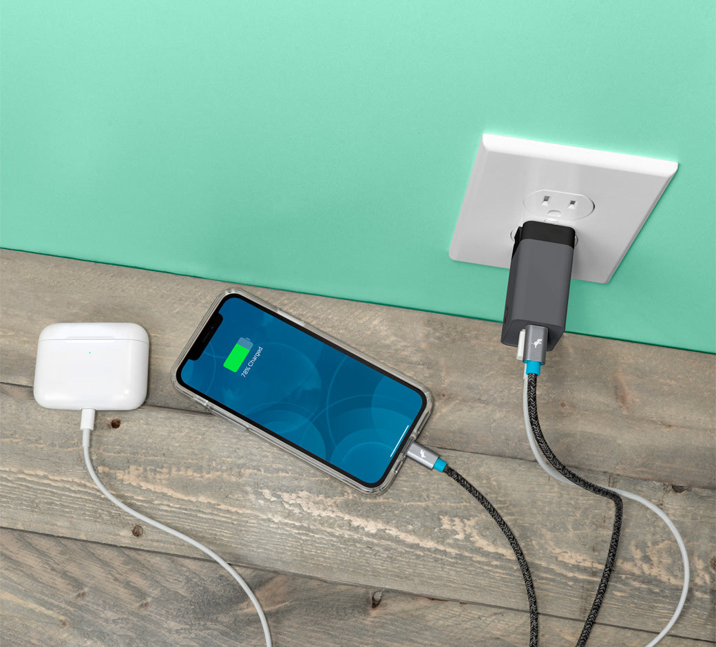 Wall charger with multiple cables, charging a phone and AirPods on a light green background.