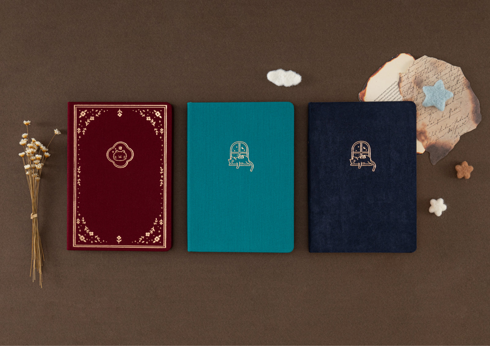 Hands holding Tsuki Neko Dreams Sleepy Neko Notebook showing teal linen cover with sleeping cat gold foil design.