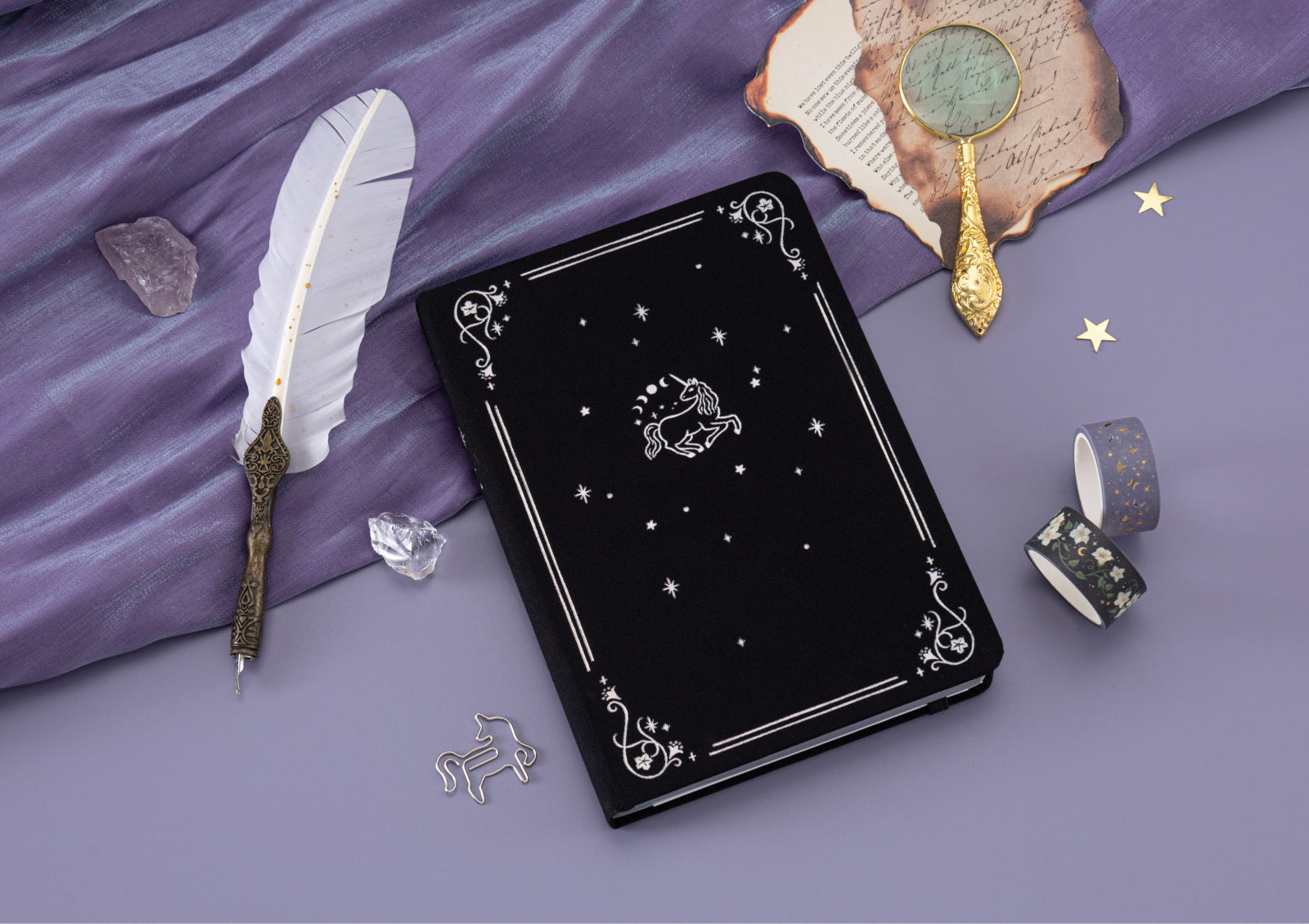 Detail shot of foiled celestial unicorn illustration on the black cover of the Tsuki Moonflower Magic notebook.