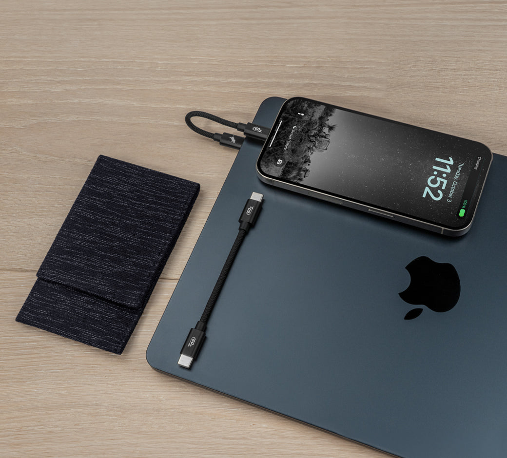 Phone charging on a laptop with a short USB-C cable and a black pouch.