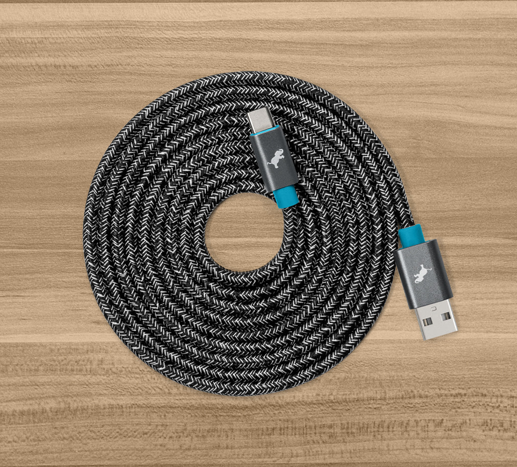 Braided black and white USB-C cable coiled neatly on a wooden surface.