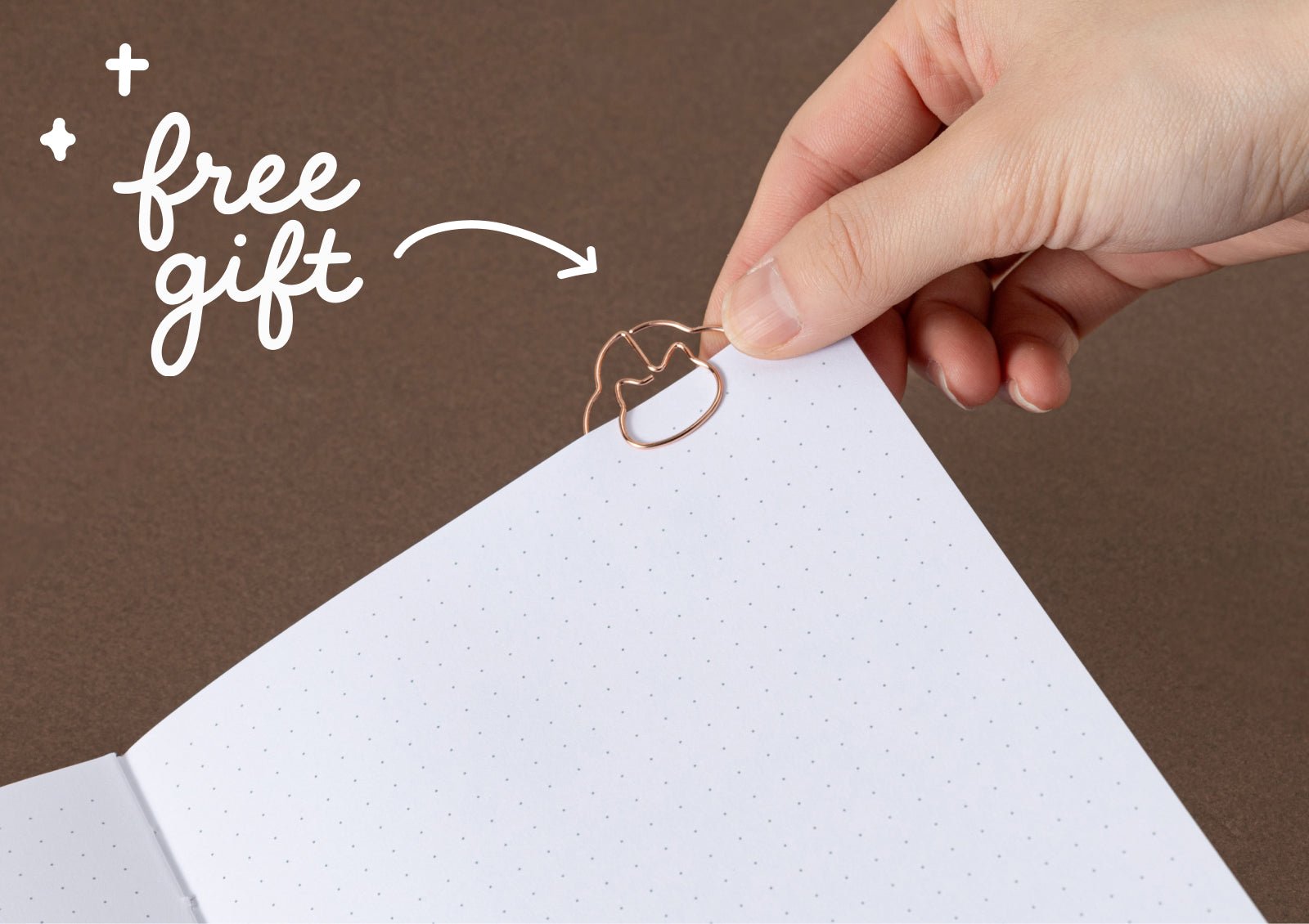 Free Neko Bouquet floral cat-shaped paper clip resting on dotted journal page.