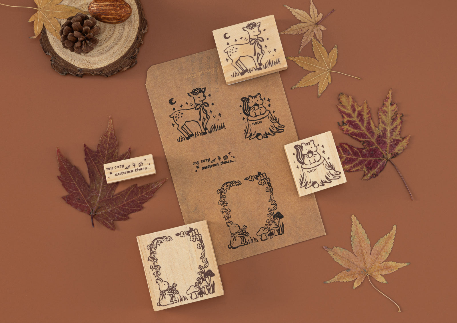 Stamped designs of a deer, squirrel, and forest frame on kraft paper using Forest Friends wooden stamps.