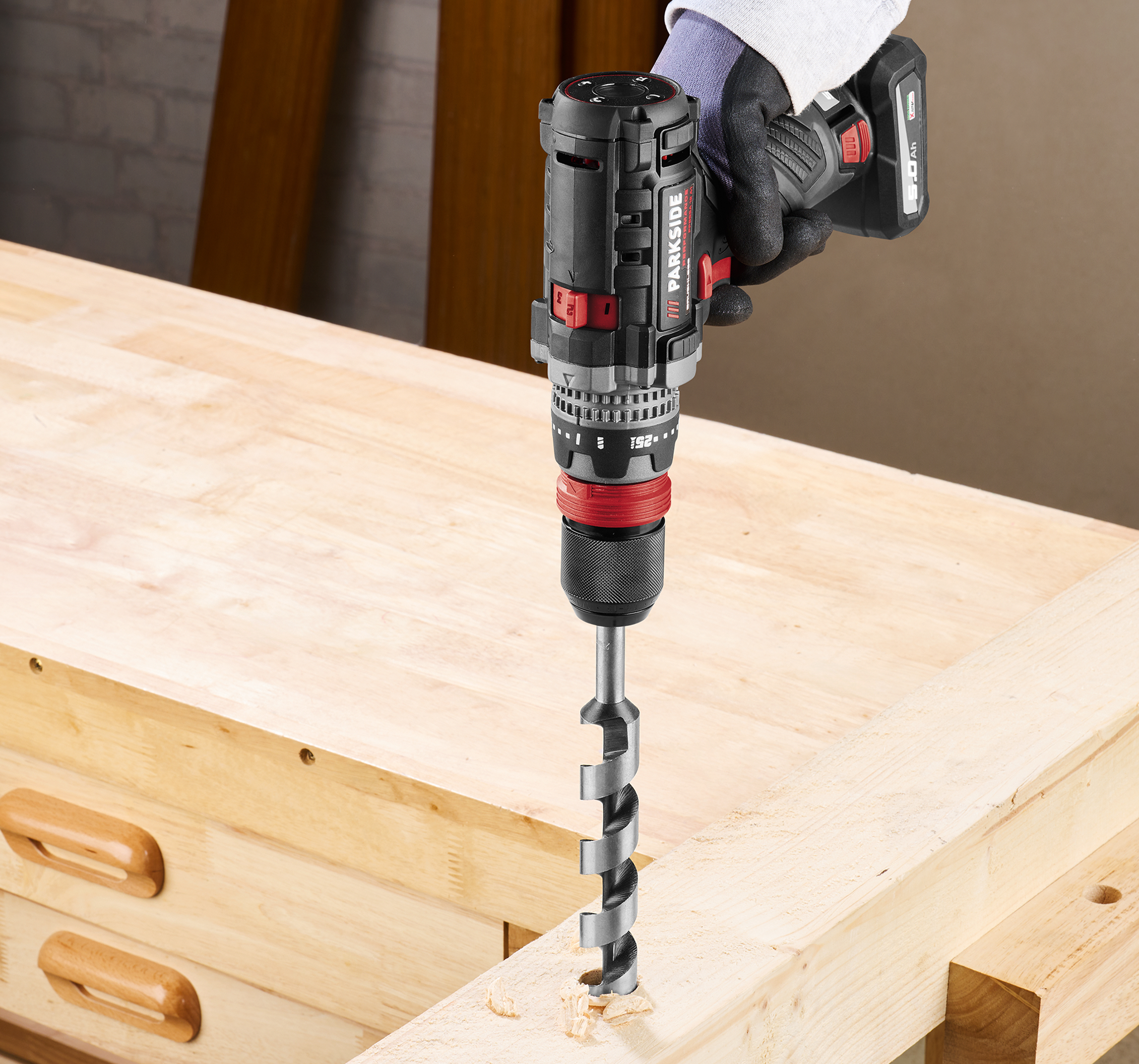 Une visseuse-perceuse Parkside perce le bois.