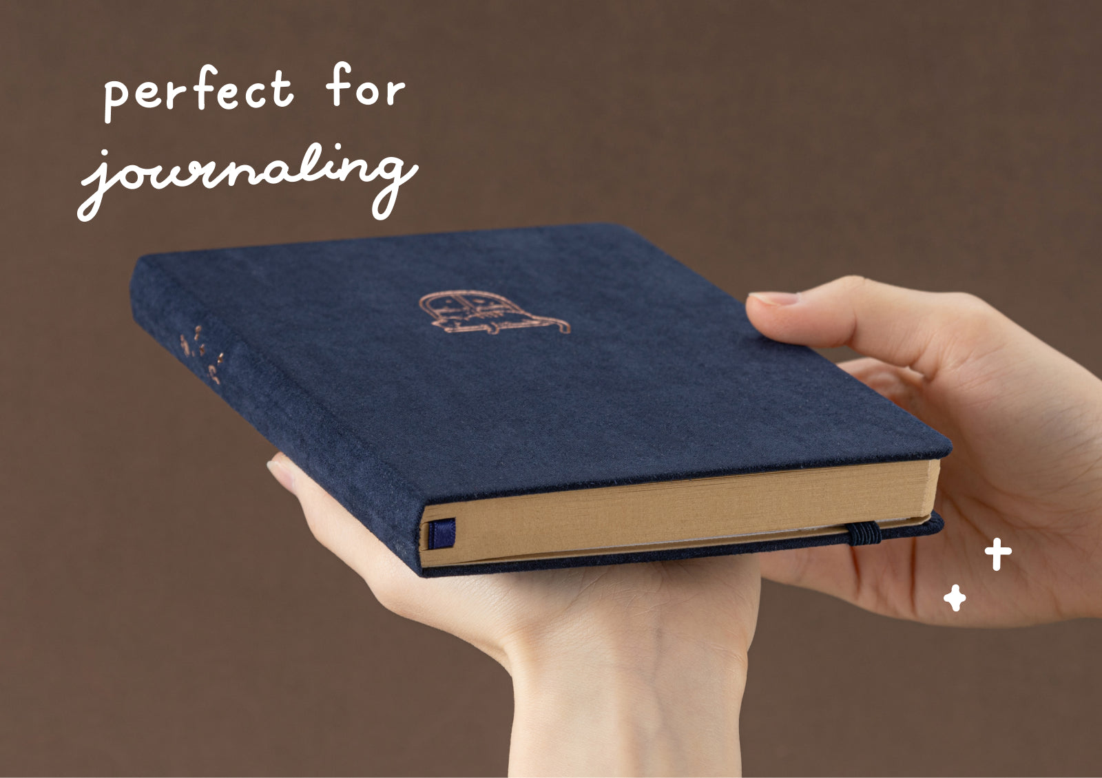 Tsuki Midnight Neko Dreams Kraft Notebook styled with celestial charms and gold pen on deep blue fabric.