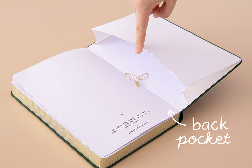 Tsuki ‘Midnight Garden’ Limited Edition Bullet Journal with open back pocket held in hand on beige background