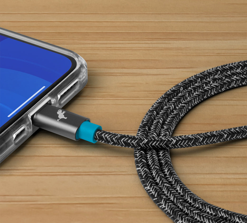 Close-up of a USB cable connected to a smartphone with a braided, black and white cable.