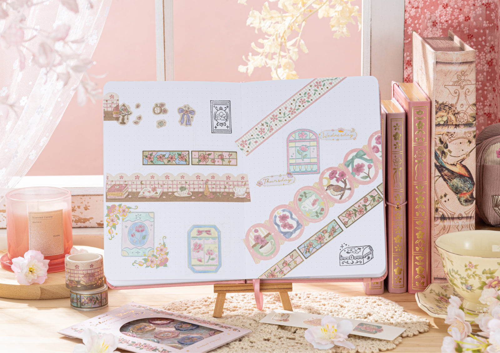 A fully decorated journal spread featuring stickers, washi tapes, and stamp impressions displayed on a small wooden easel.
