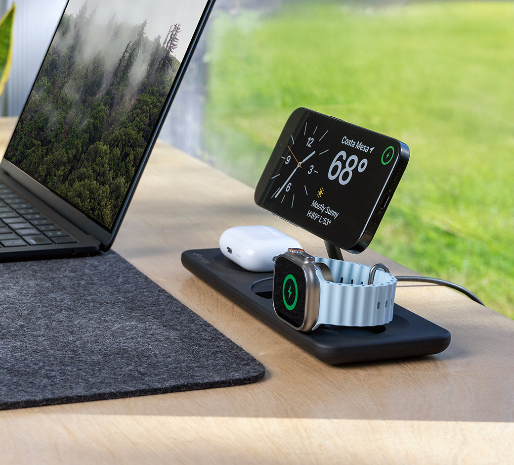 Charging dock with multiple devices, showing green charging indicators.