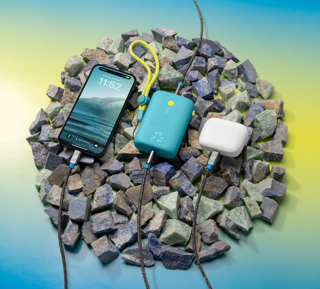 Turquoise charger connected to a phone on colorful stones.