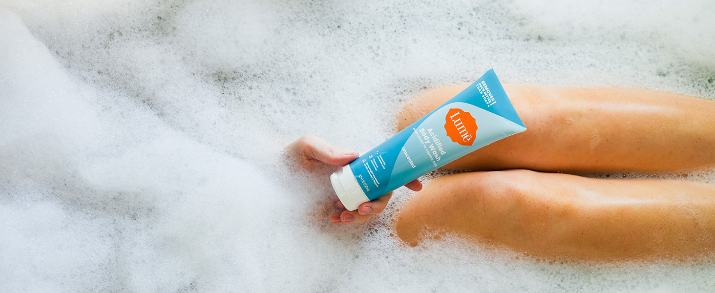Lum� Acidified Body Wash in Unscented being used in a bath tub