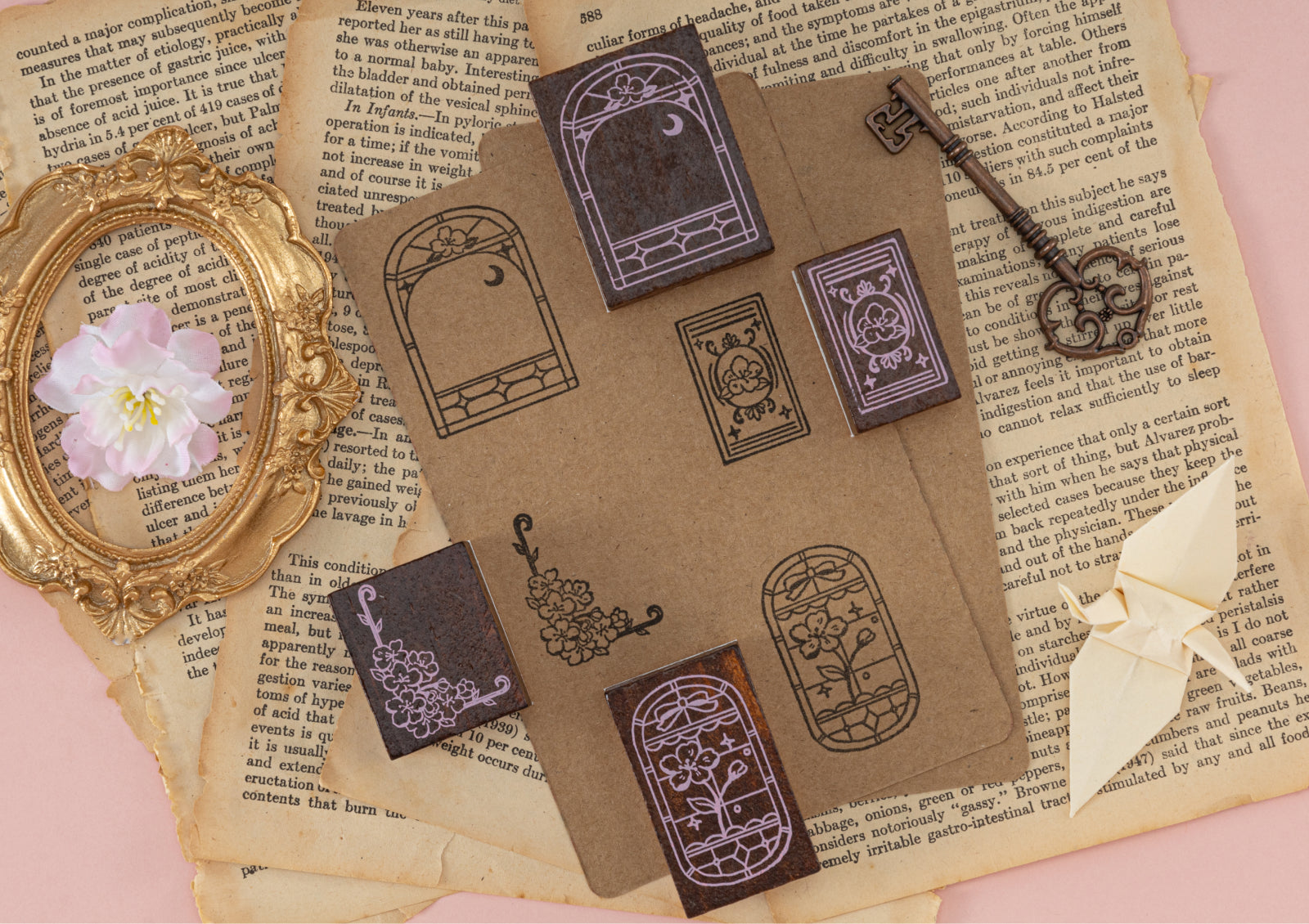 Stamp impressions on vintage brown paper pieces shown with a bronze key and cherry blossom flowers.