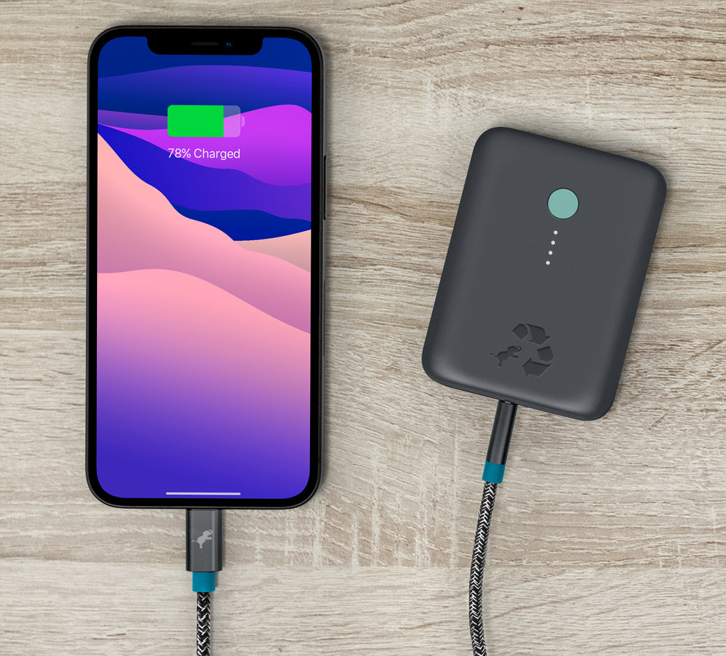 Smartphone charging with a portable power bank using a braided USB cable.