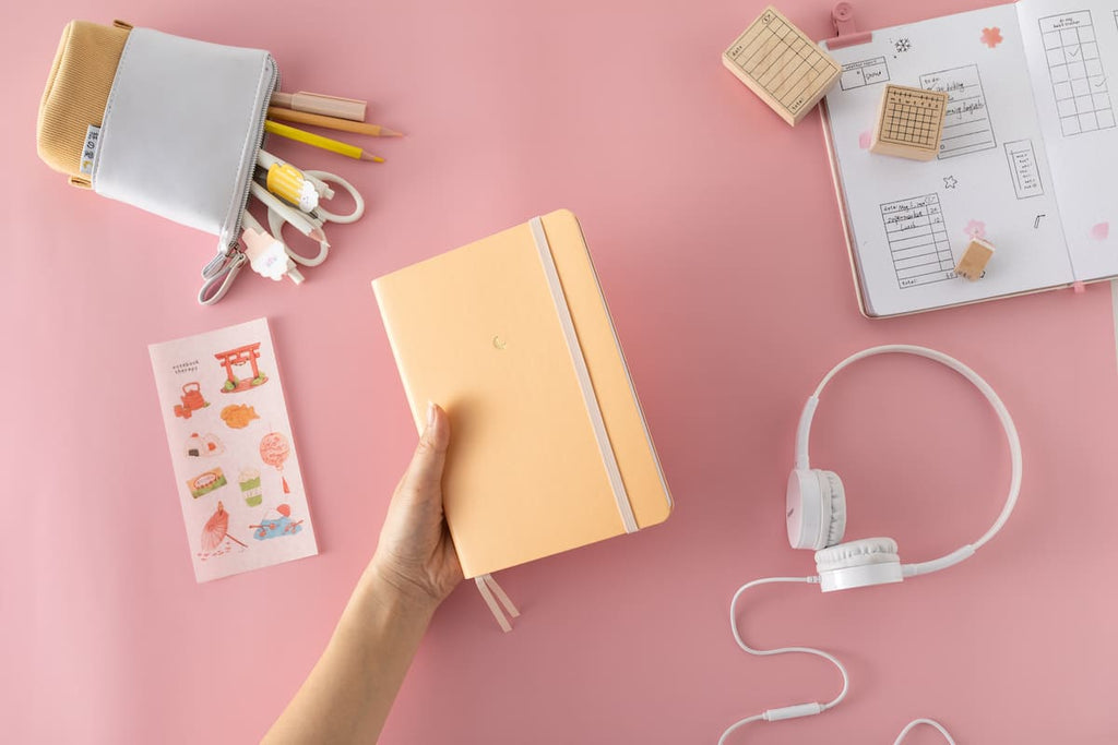 handheld orange notebook