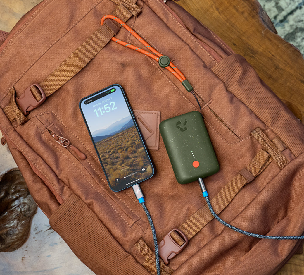 Green charger on a brown backpack connected to a phone.