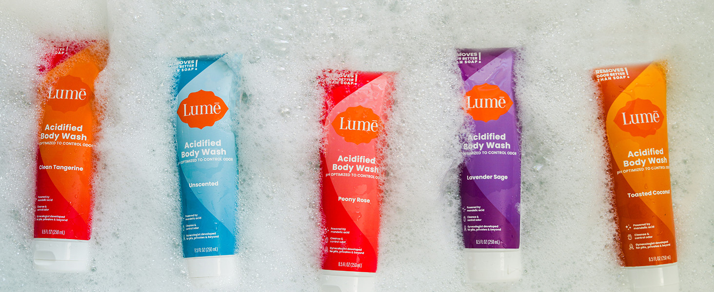Lum� Acidified Body Wash in available scents floating in a bath tub