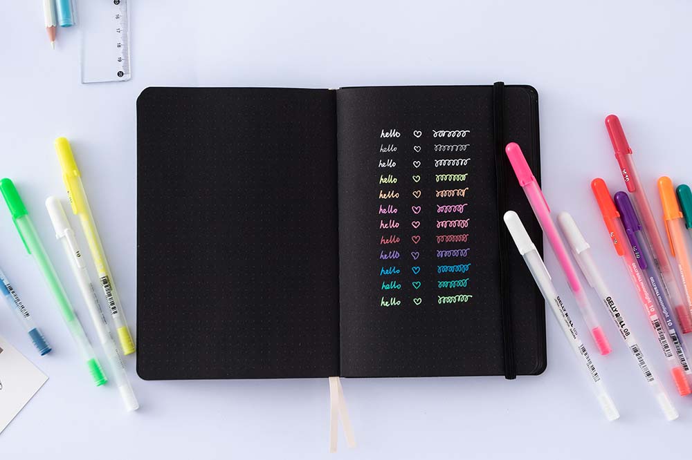 Open Tsuki Black Paper Limited Edition Hardcover Bullet Journal with Gelly Roll Pens on light grey background